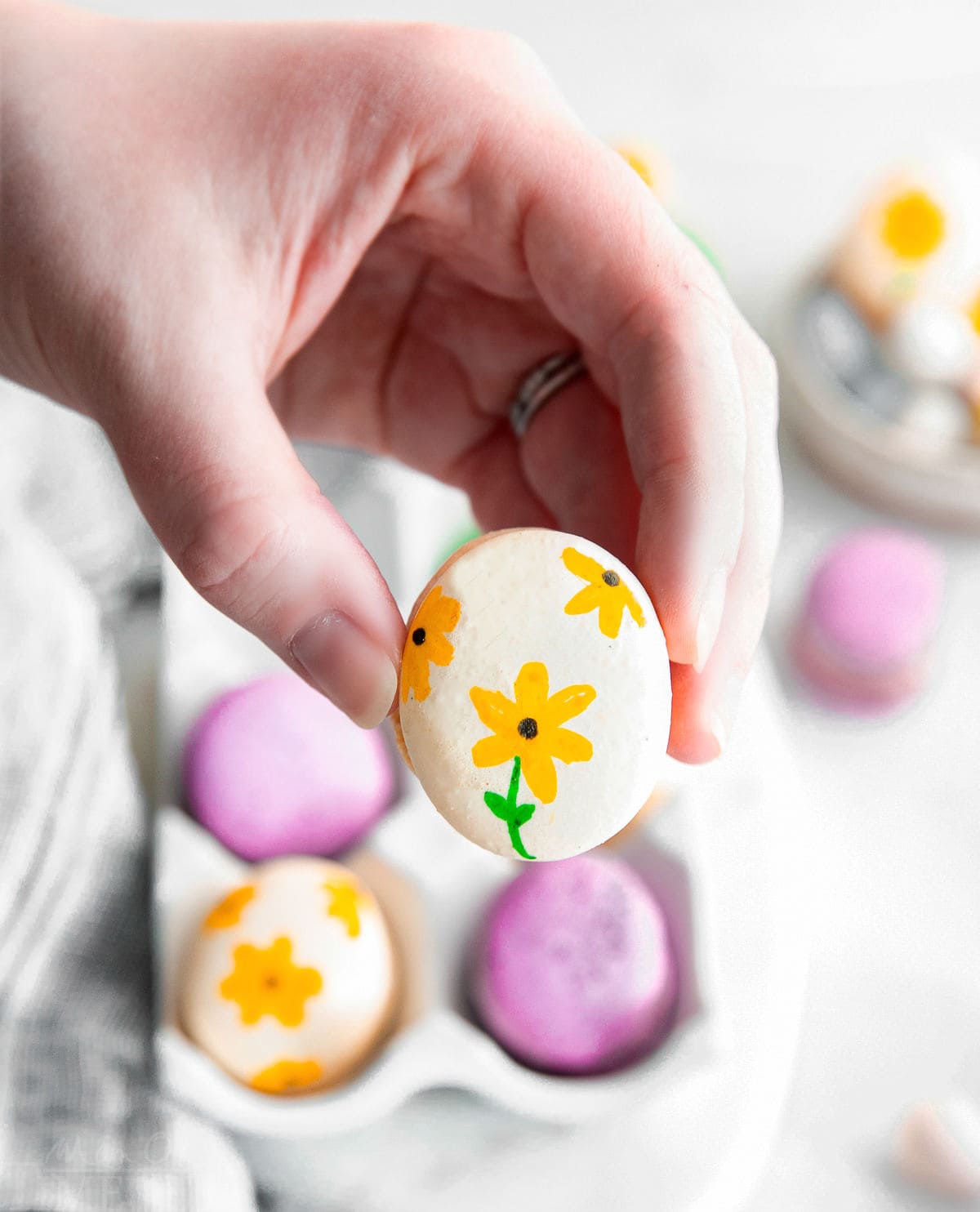 hand painted macaron being held.