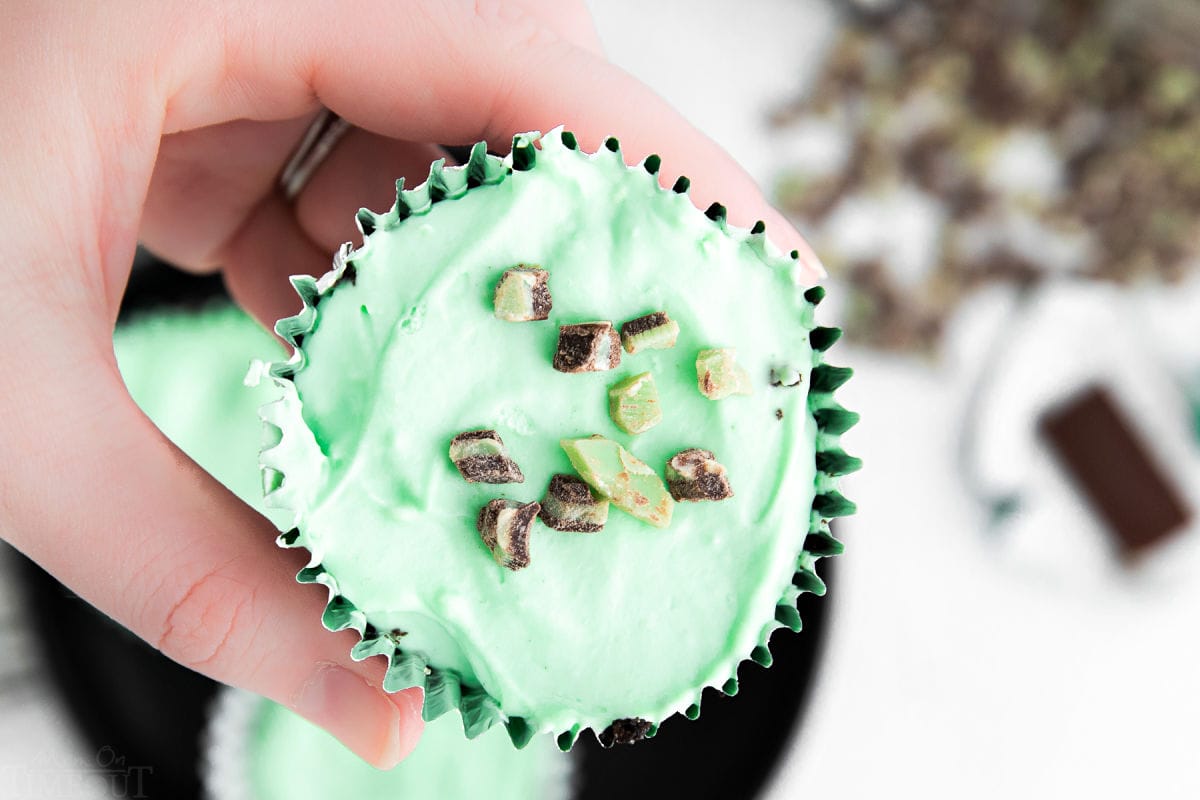 mini mint cheesecake with andes chips on top being held.