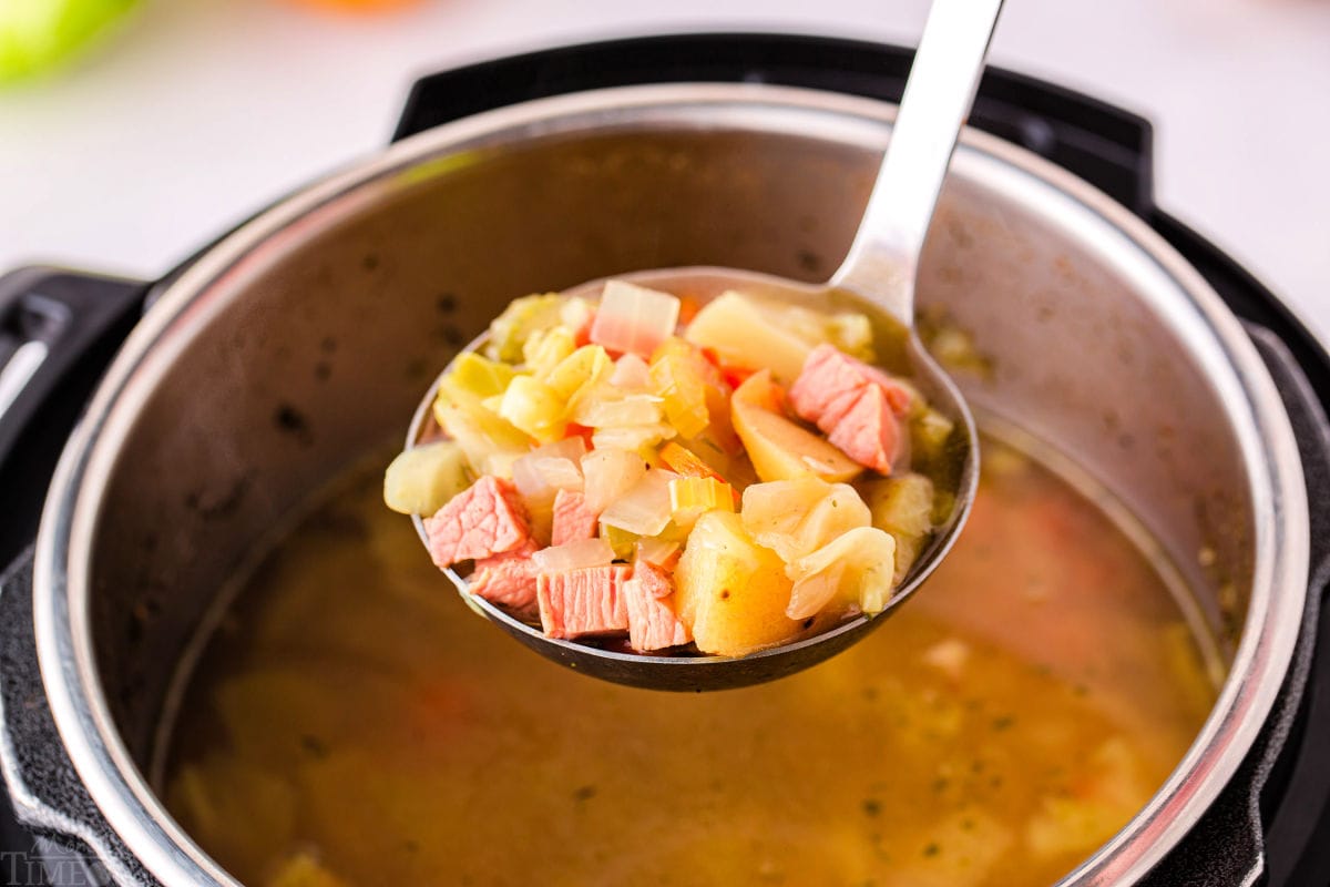 ladleful  of soup being held over instant pot.