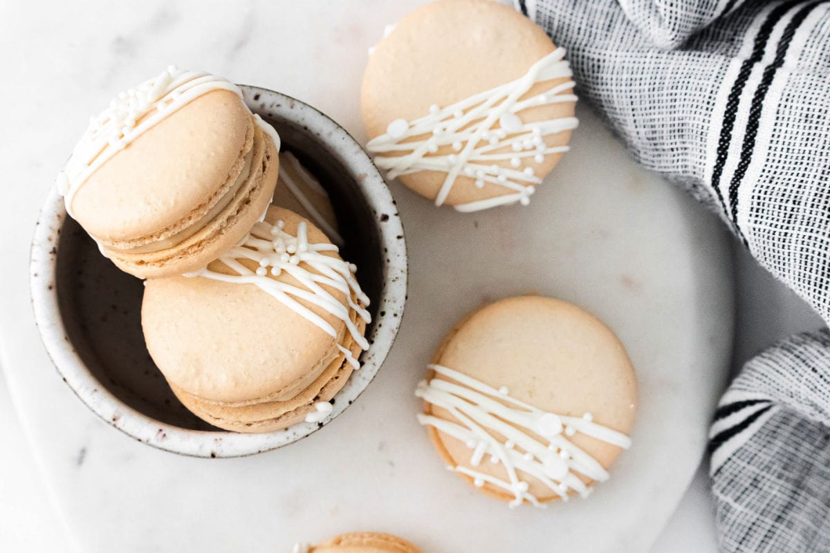 top down look at macarons decorated with white chocolate.