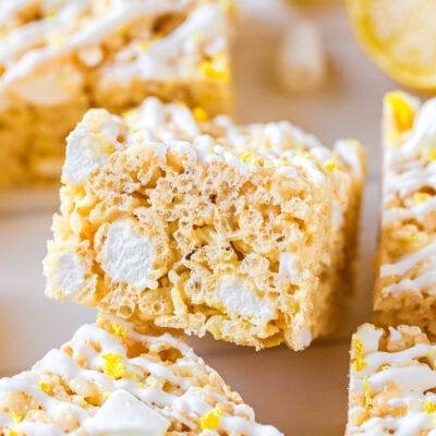 lemon rice krispie treat cut into a square with lemon zest and white drizzle on top.
