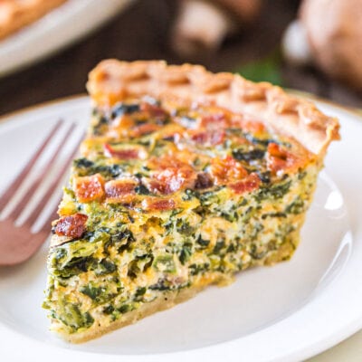 piece of spinach quiche on white plate.