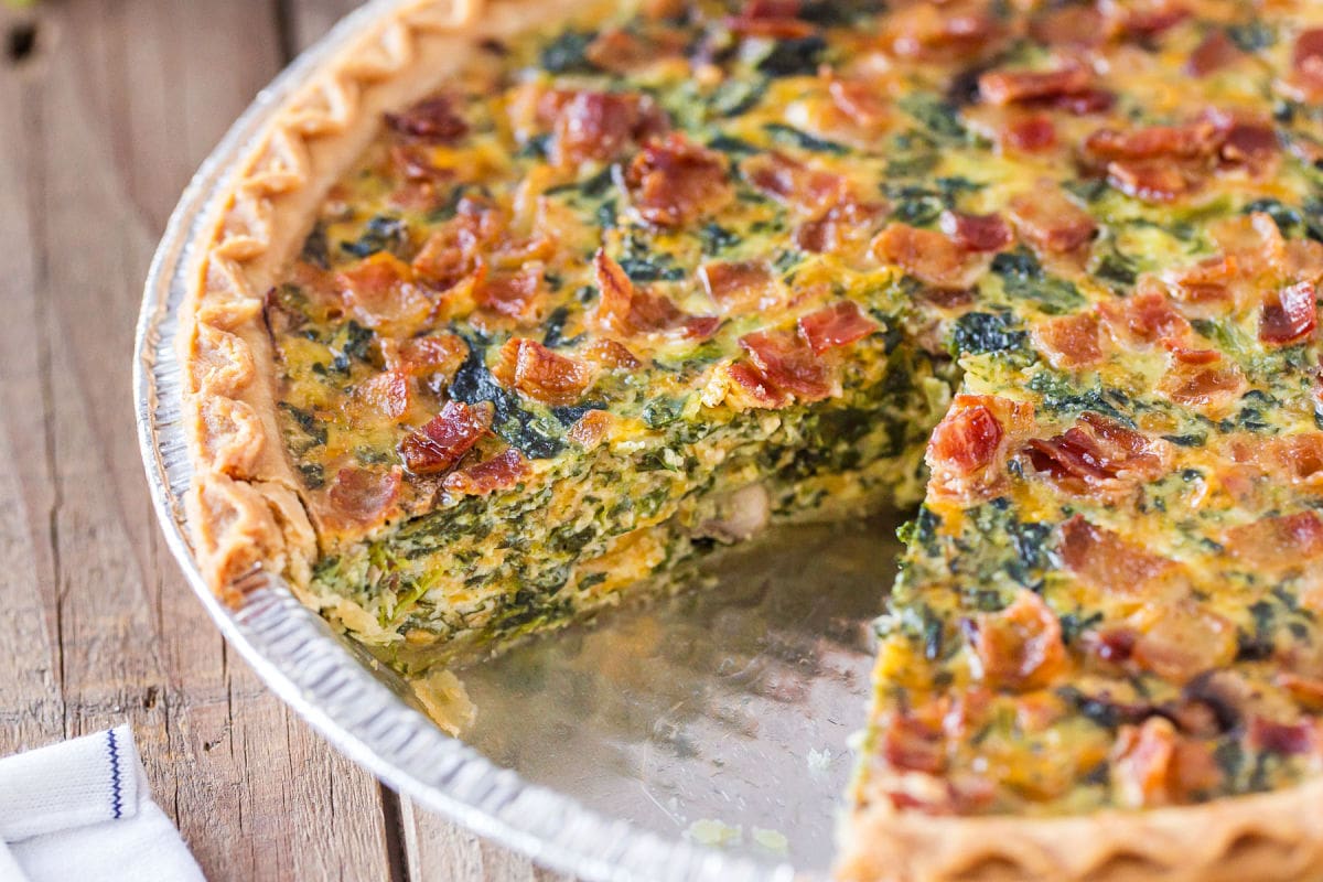 spinach quiche recipe with piece removed.