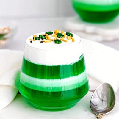 layered green and white jello cups on marble surface.