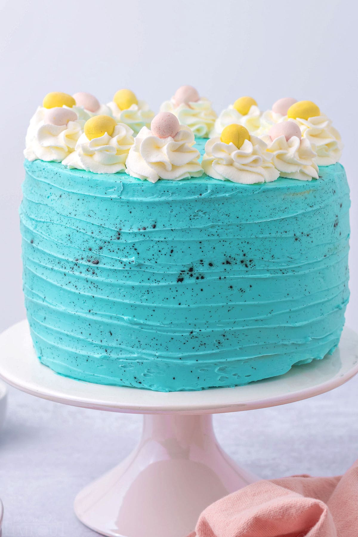 whole easter cake decorated with turquoise frosting and cadbury eggs.