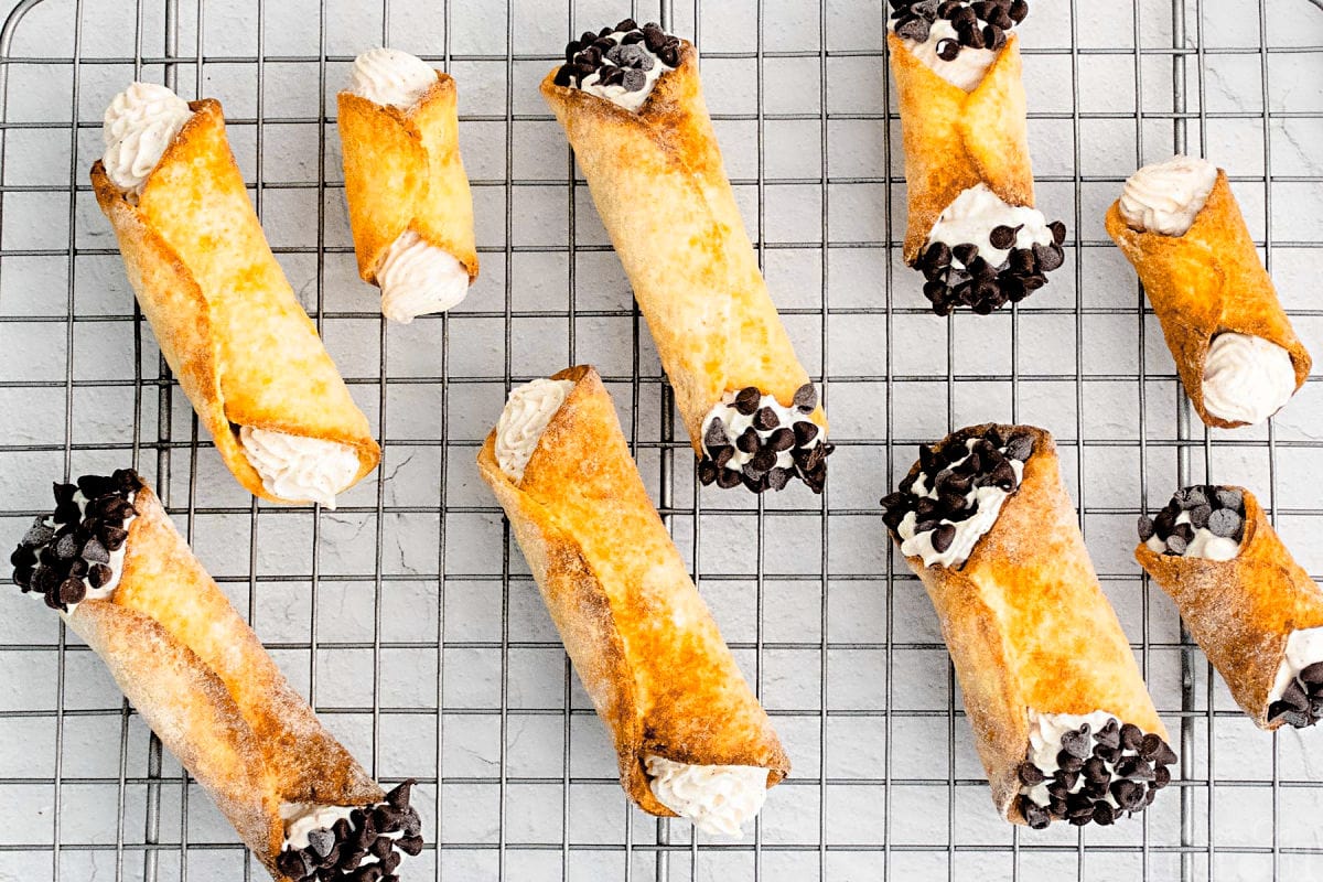 filled cannolis on metal rack ready to eat.