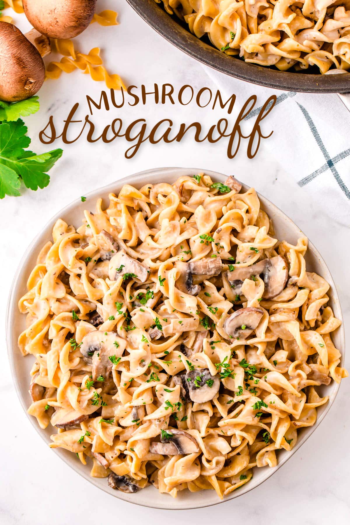 top down view of mushroom stroganoff piled high on round white plate garnished with parsley. text overlay at top of image.