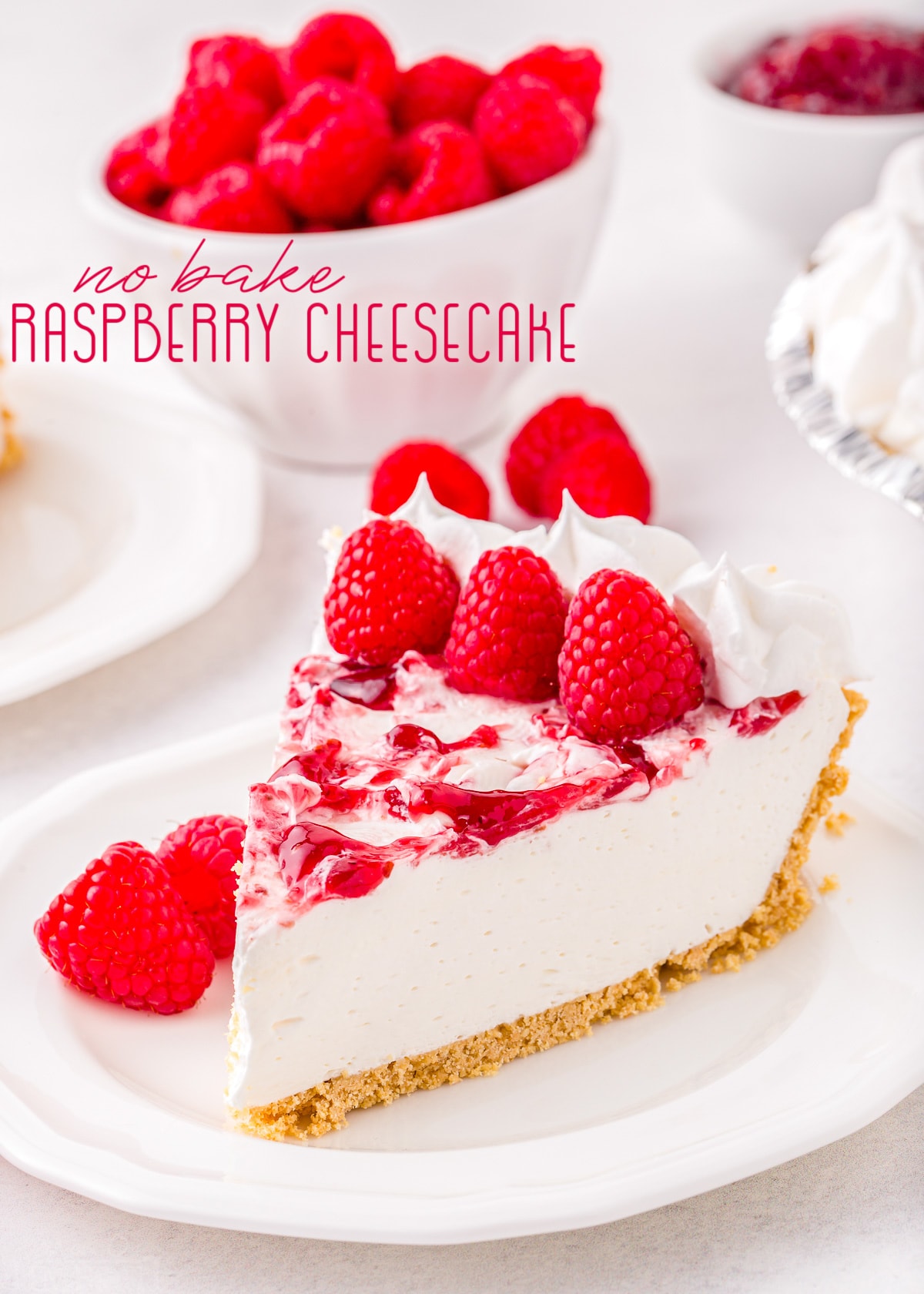 piece of cheesecake on plate garnished with fresh raspberries with title overlay.