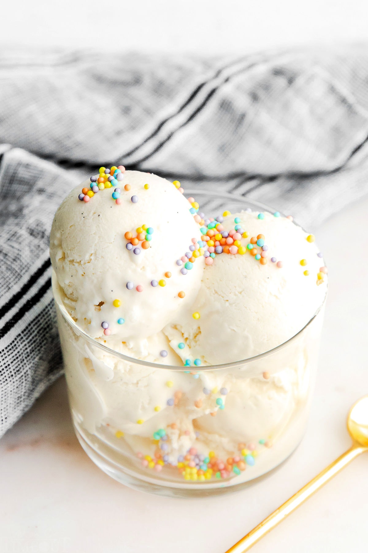 top down look at scooped vanilla ice cream in clear glass cup.