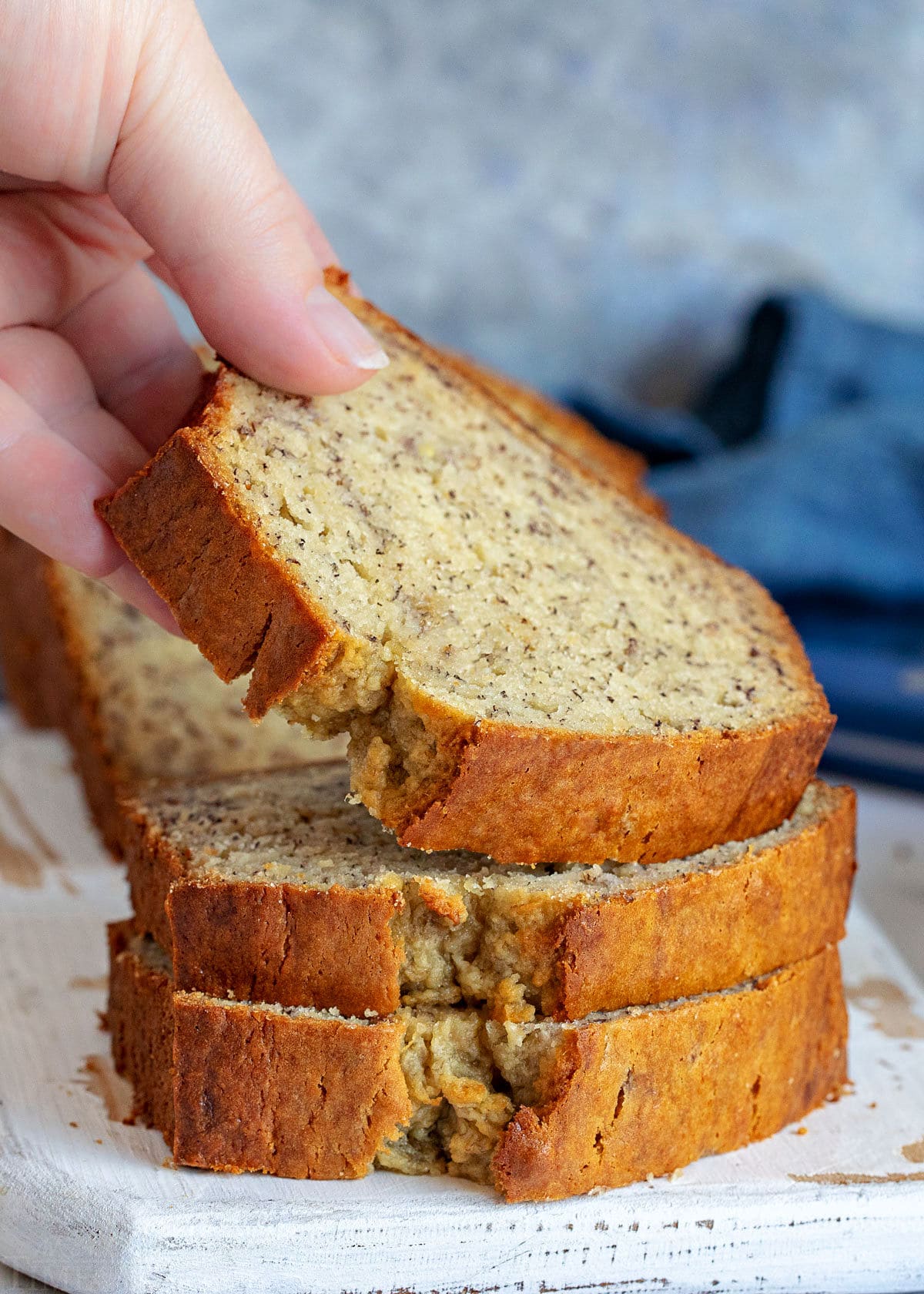 stack of banana bread with one slice being picked up.