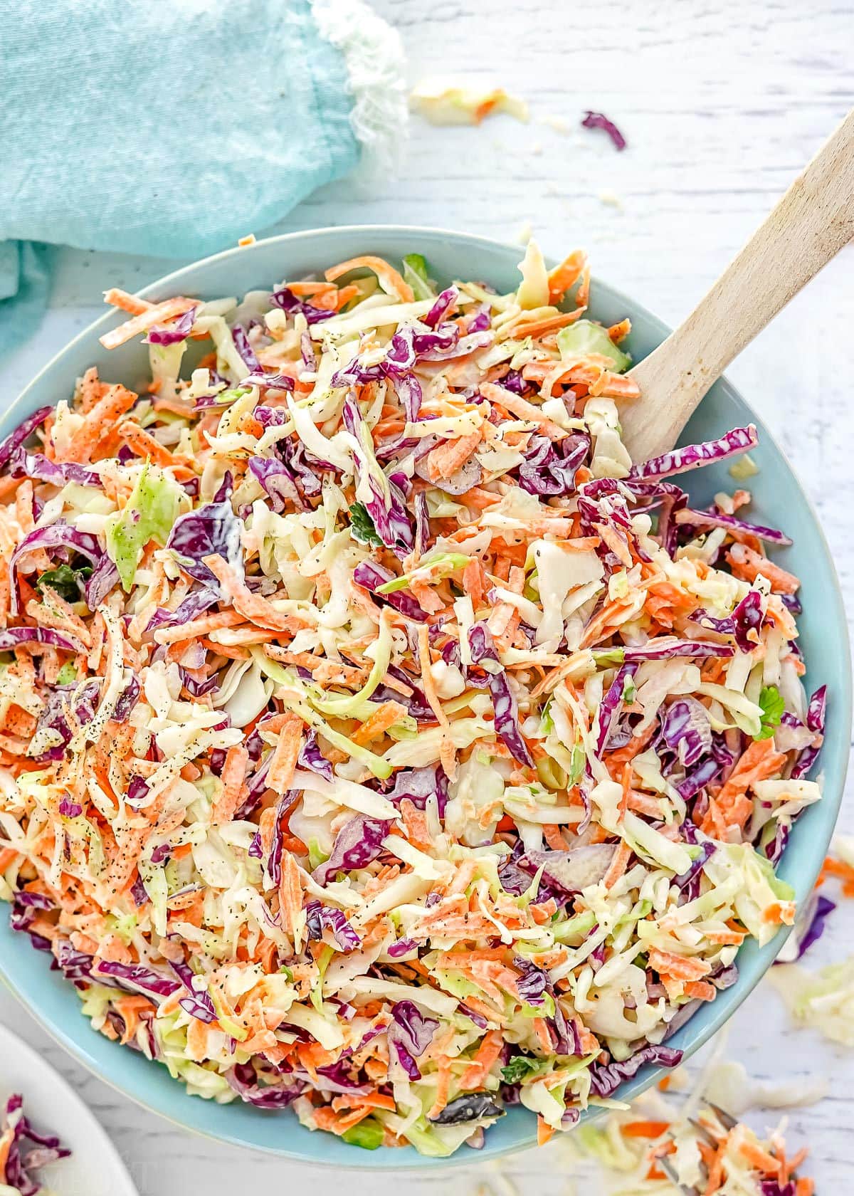 close up look at tri colored coleslaw in light blue bowl ready to be served.