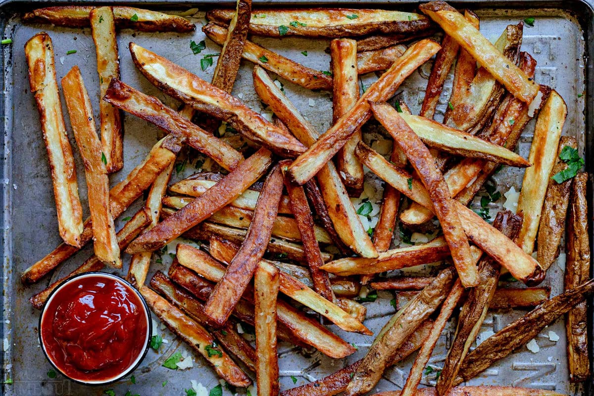 golden fries on baking sheet after being baked in the oven.