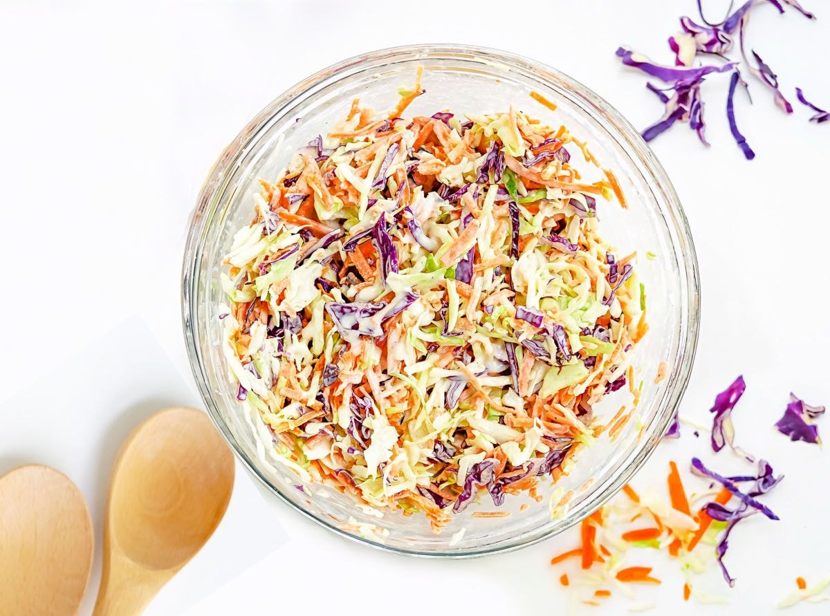 cole slaw recipe tossed together in glass mixing bowl.