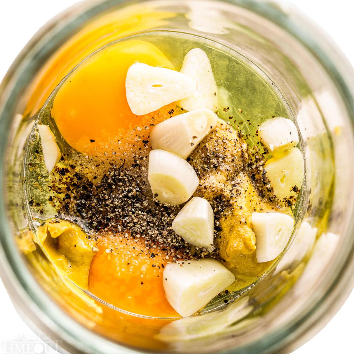 ingredients for aioli all combined in glass jar.