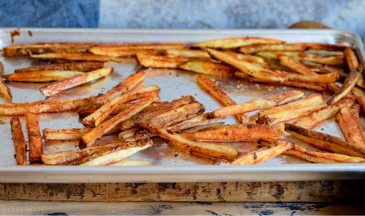 golden and crispy oven baked french fries on large baking sheet.