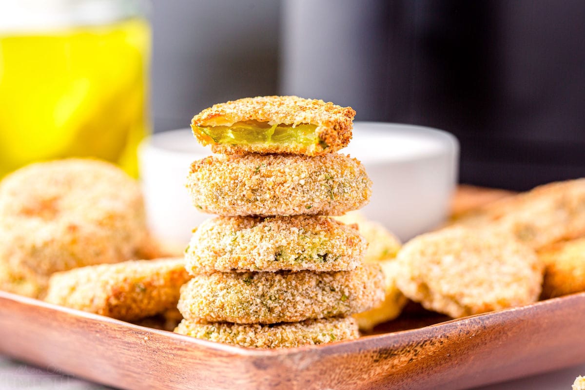 air fryer pickles stacked 5 high with the top pickle bitten in half.