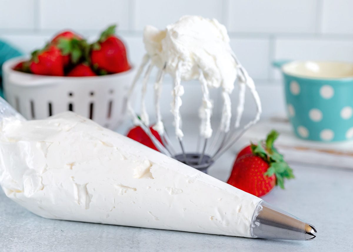 whipped cream in a piping bag and on a whisk attachment.