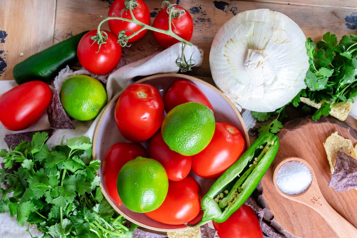 top down view of pico de gallo ingredients laid out on wood board. 