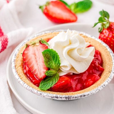 single strawberry pie on white plate made in graham cracker crust.