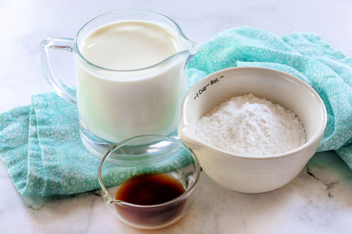 whipped cream ingredients measured out into small container sitting in front of a blue napkin.