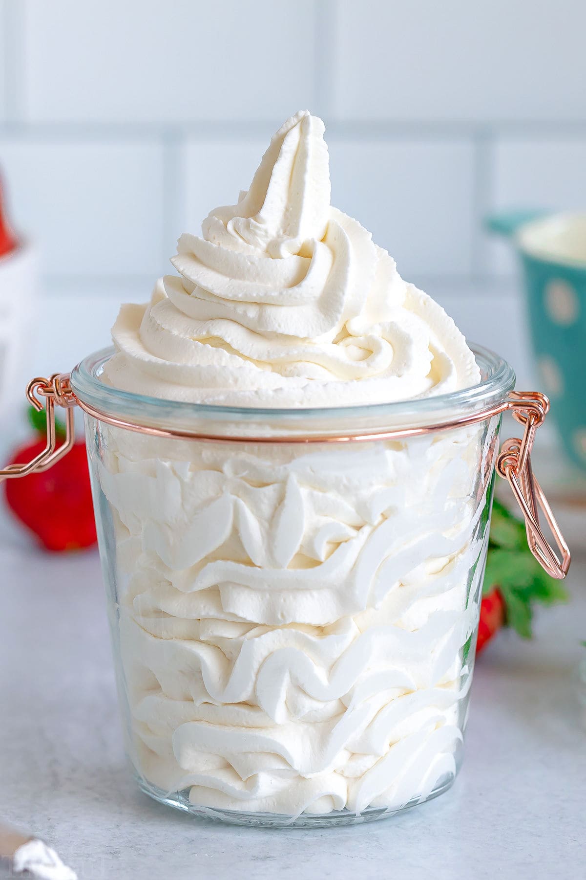stiff whipped cream piped into tall glass jar with gold hinge.