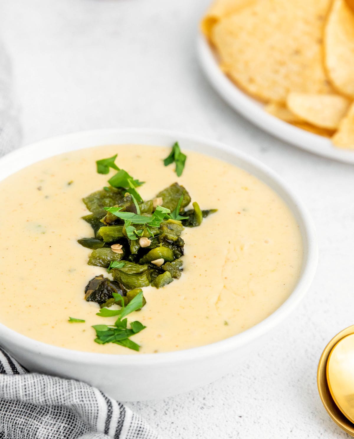 white queso in white bowl garnished with cilantro.