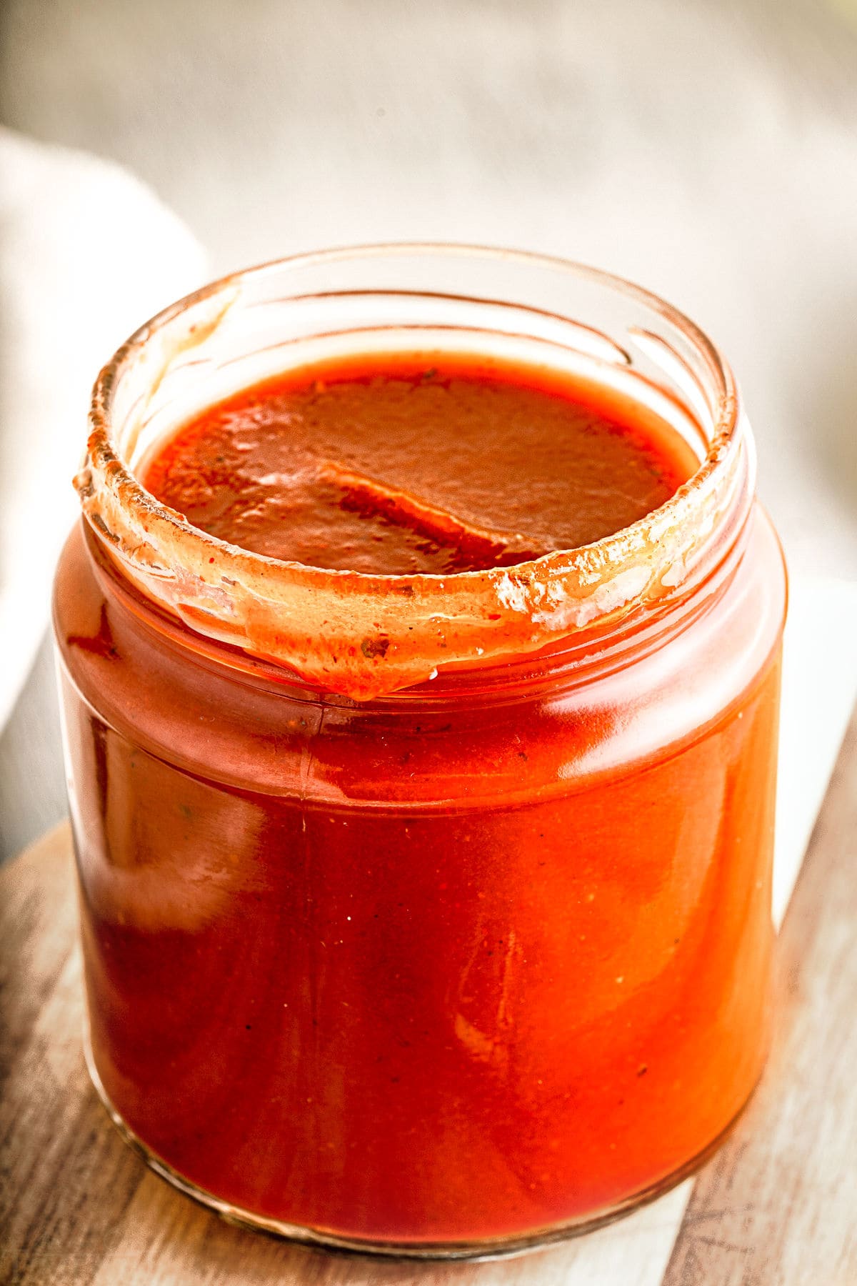 bbq sauce in glass jar on wood board.