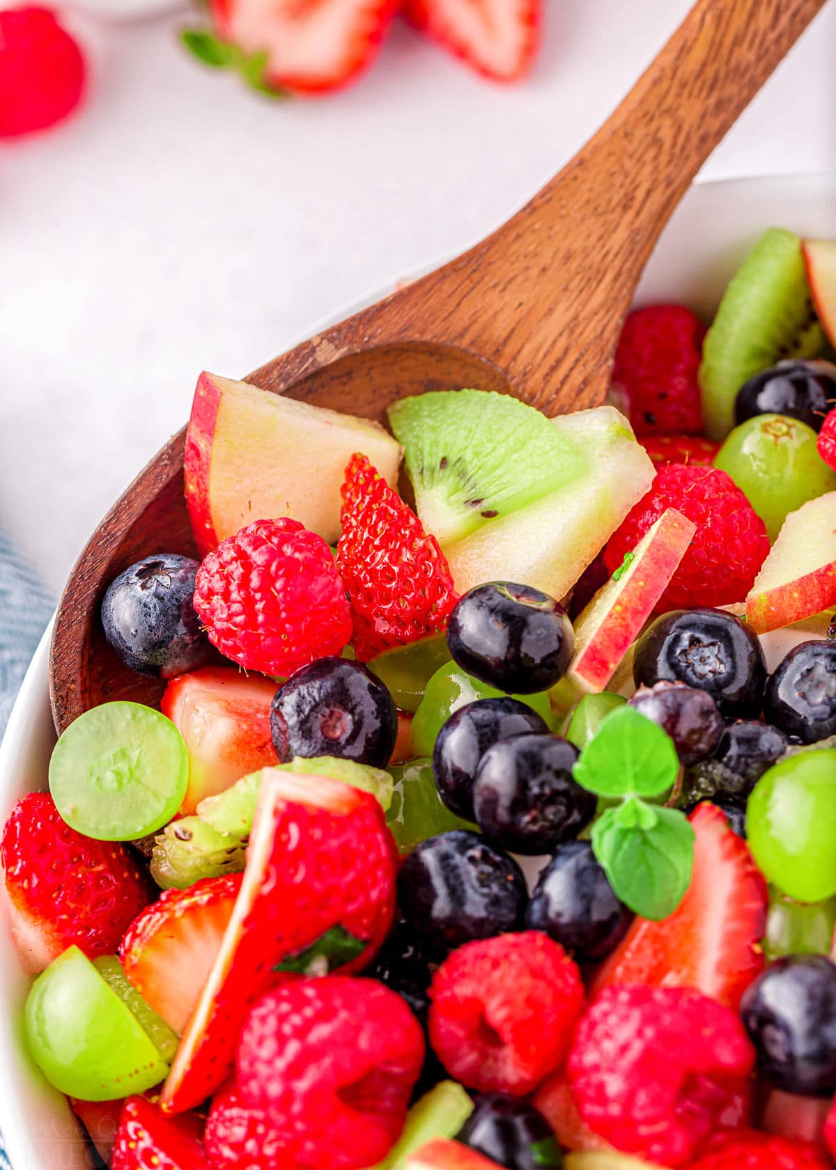 spoonful of fresh fruit salad in serving bowl.