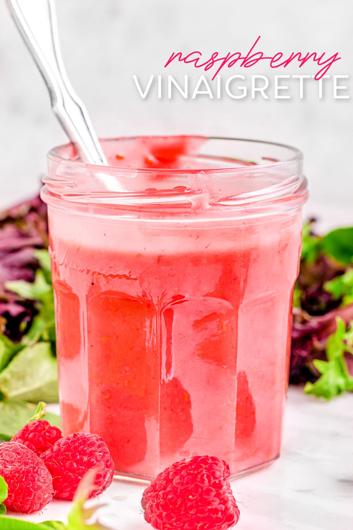 raspberry vinaigrette in glass jar with small spoon in jar. title overlay at top of image.