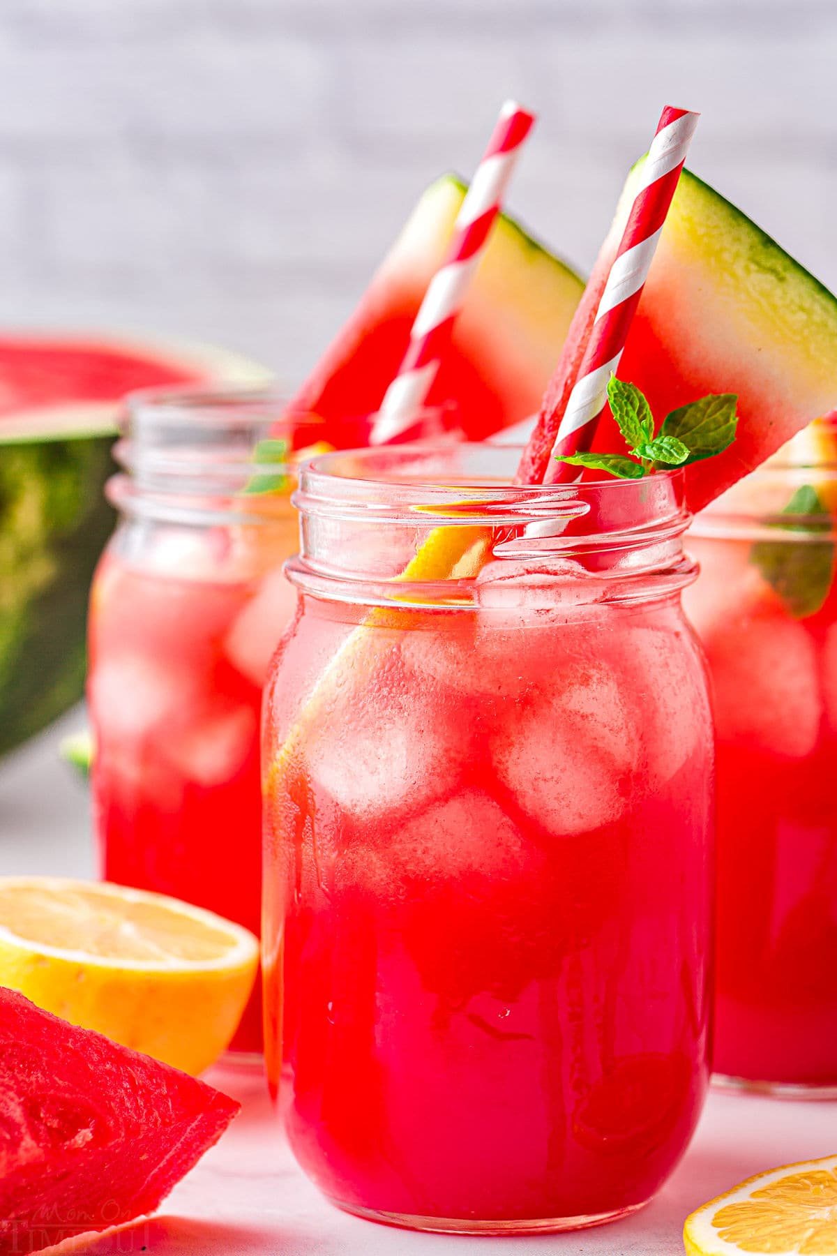 watermelon lemonade serve with striped straws and watermelon slices.