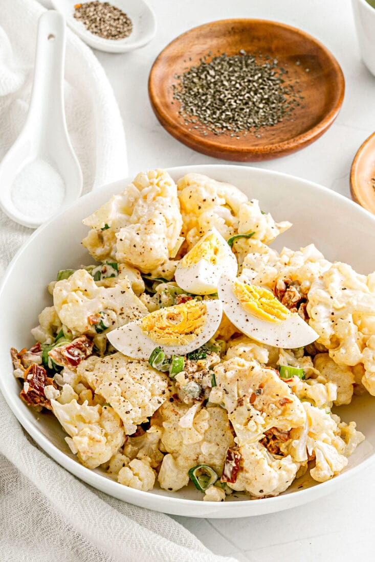 cauliflower salad made like potato salad in white bowl ready to serve.