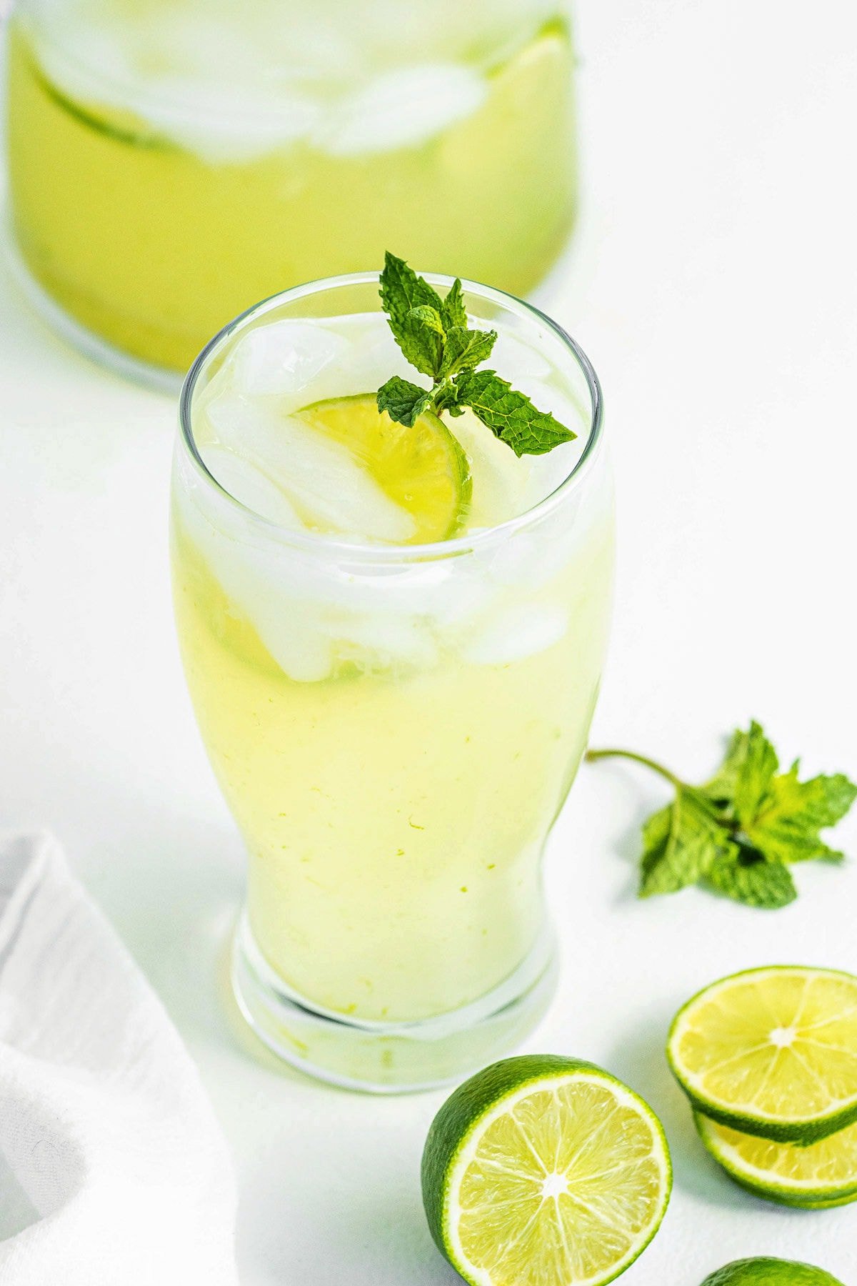 top down look at limeade in a tall clear glass topped with a sprig of mint.