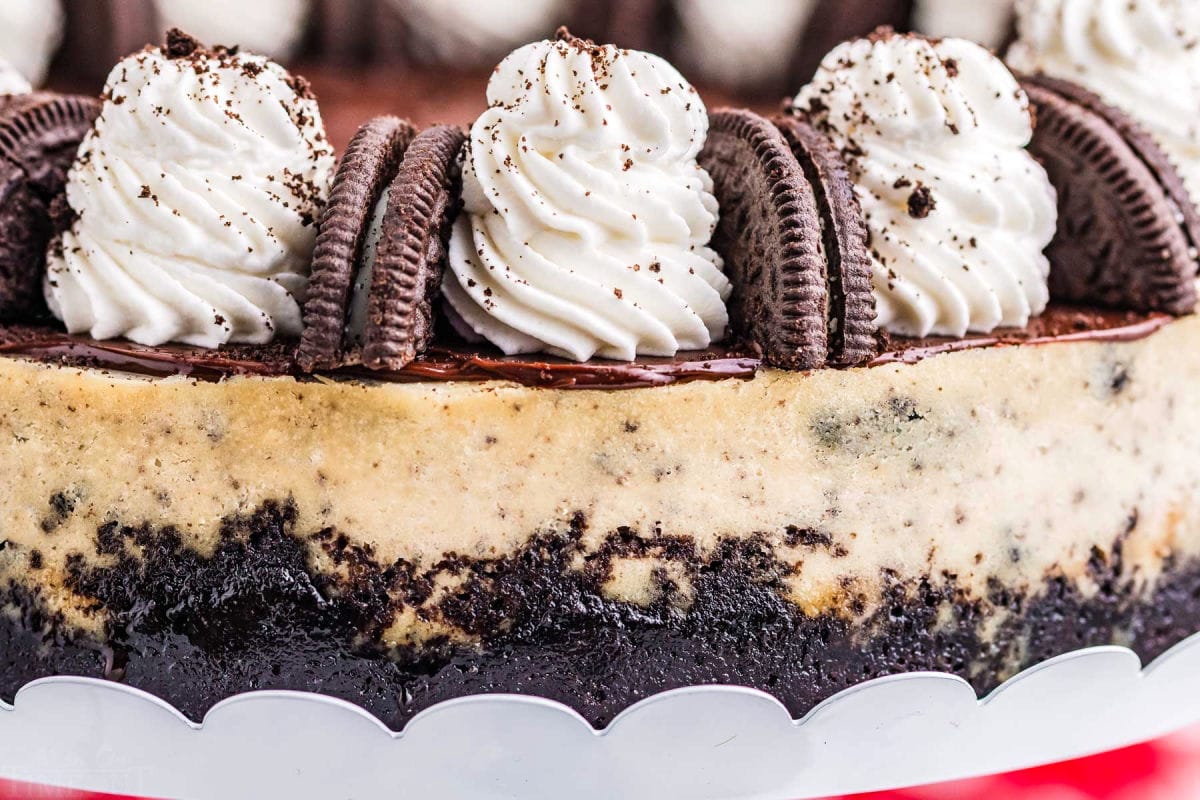 close up look at whipped cream and oreos on top of cheesecake.