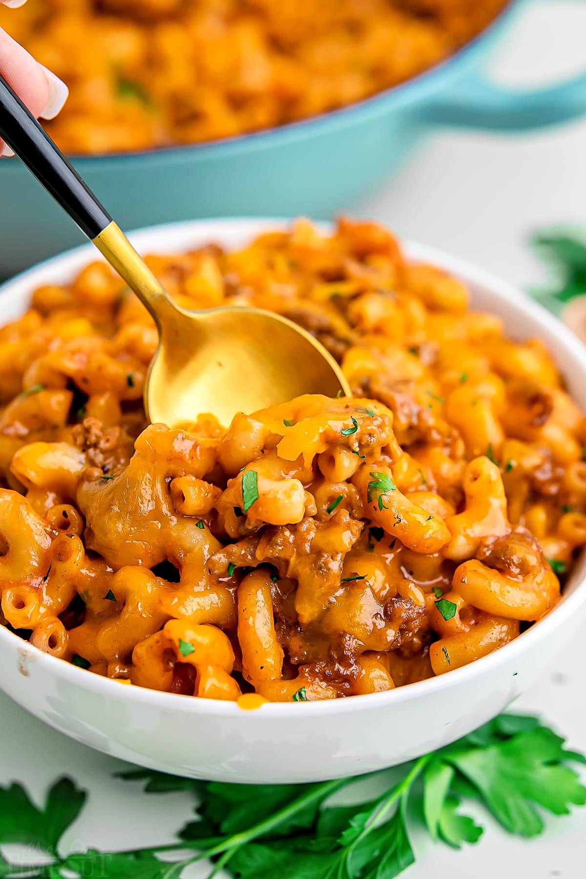 bowl of homemade hamburger helper ready to eat with a gold spoon inserted in the bowl.