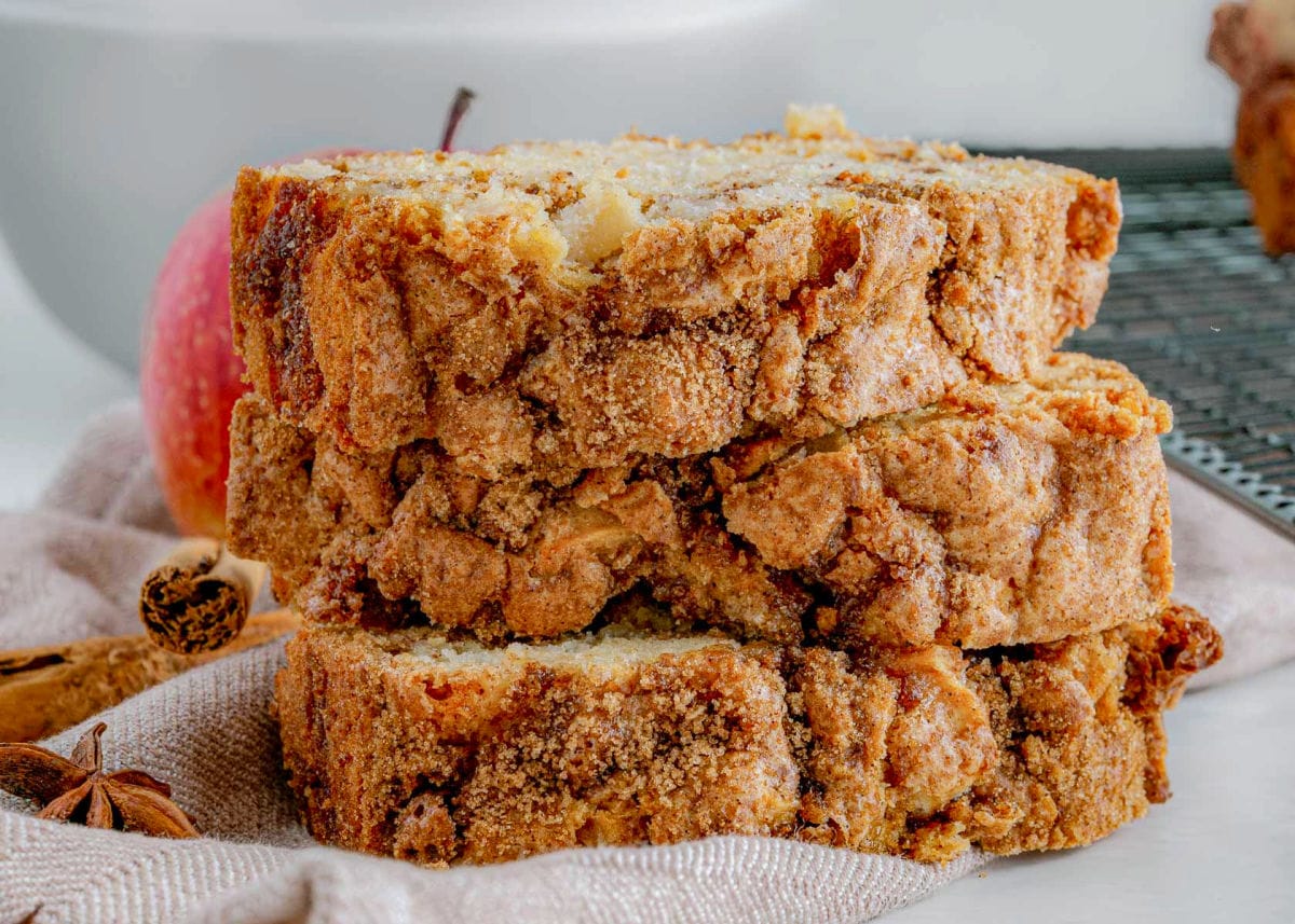 up close look at streusel topping on apple bread. three slices stacked on top of one another.