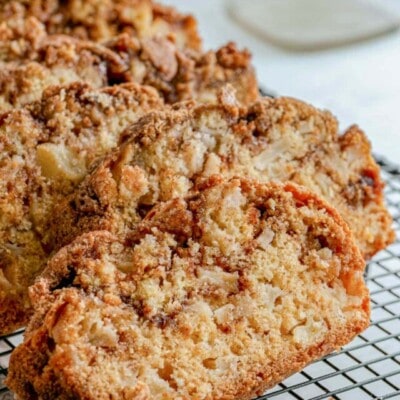 four slices of apple bread on black cooling rack.