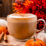 perfect mug of homemade pumpkin spice latte sitting olive board ready to be enjoyed.