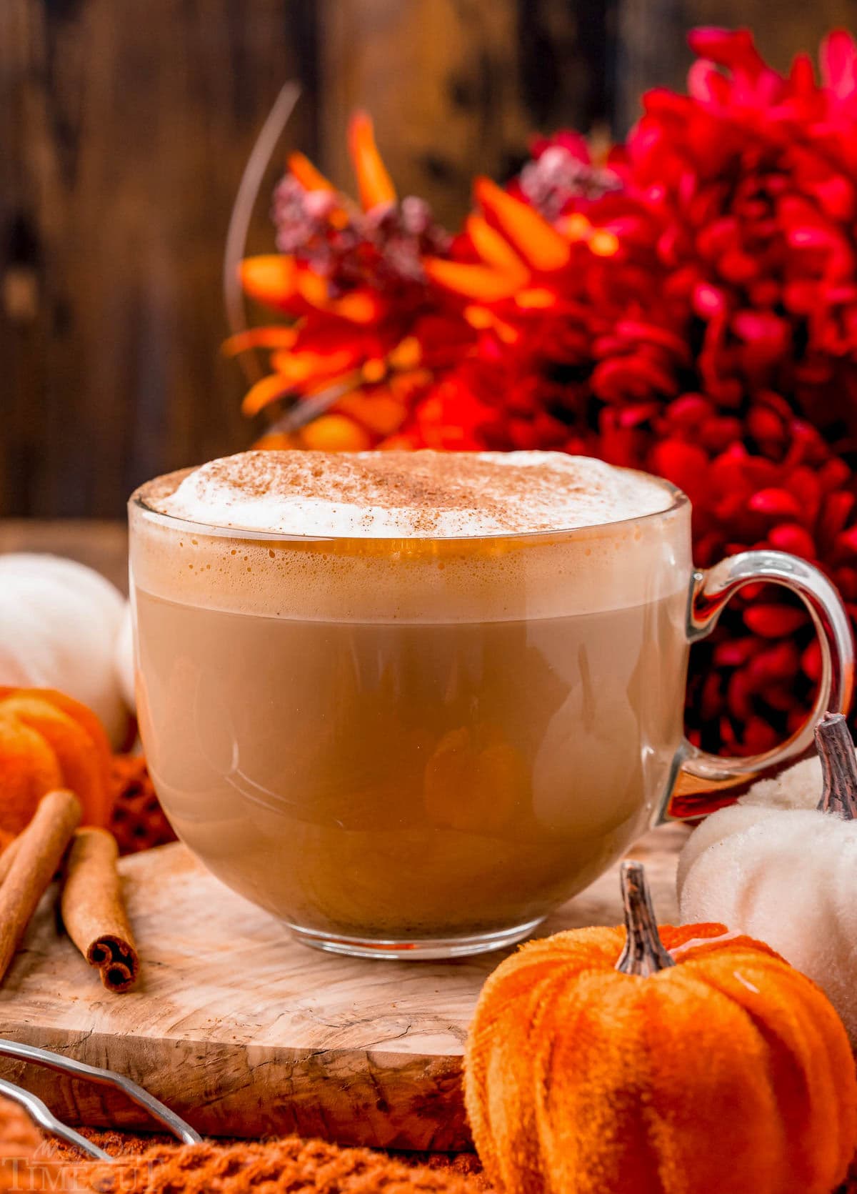 perfect mug of homemade pumpkin spice latte sitting olive board ready to be enjoyed.