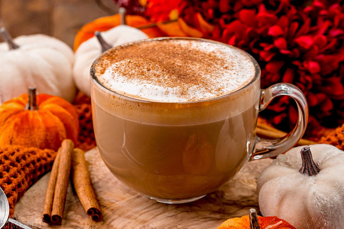 angled view of pumpkin spice latte so you can see the layers in the glass mug as well as the pumpkin pie spice topping.