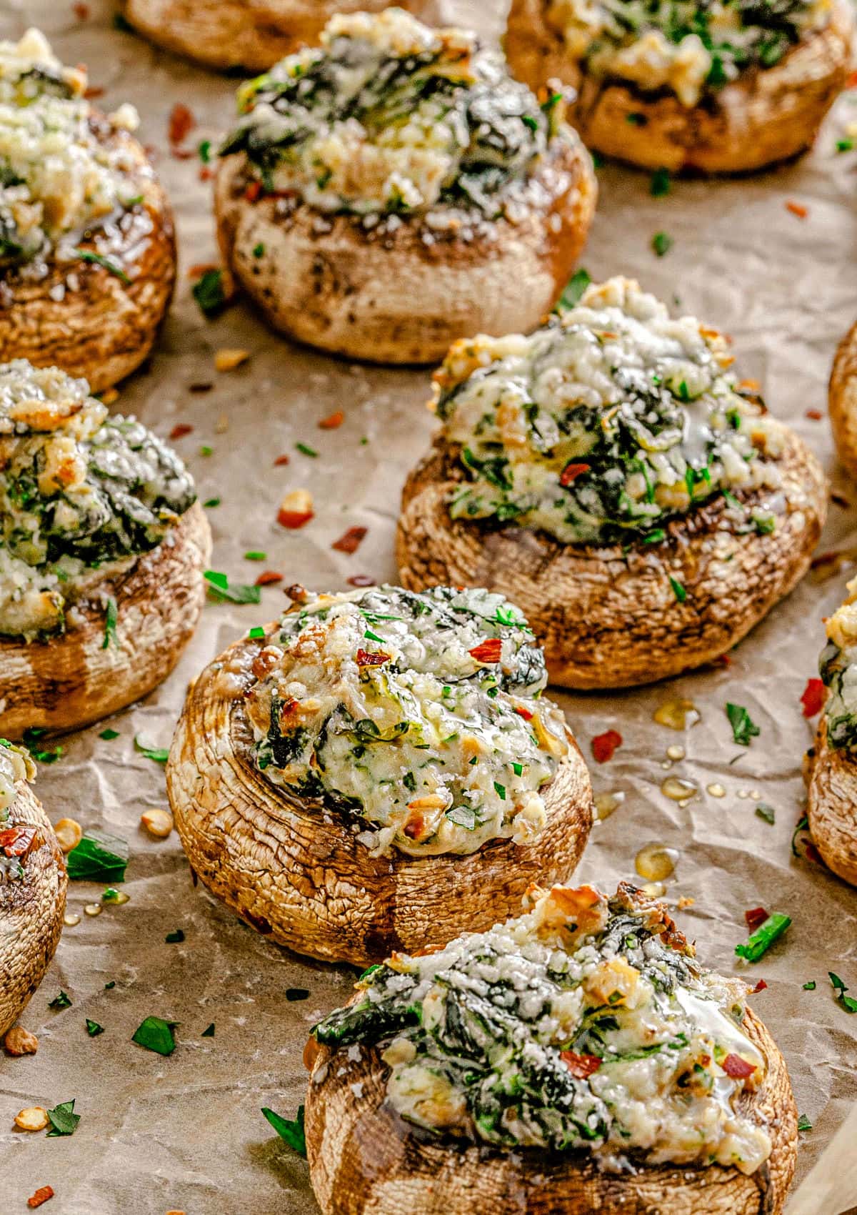 stuffed mushrooms made with spinach and cream cheese on brown parchment paper ready to enjoy.