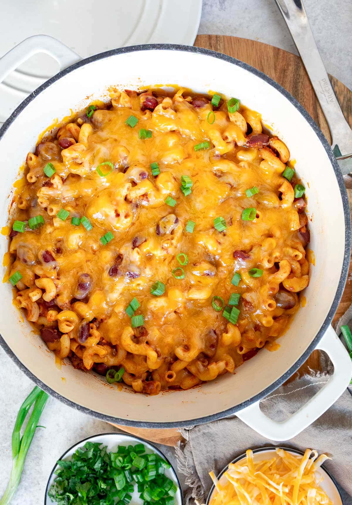 top down look at chili and macaroni in white dutch oven.