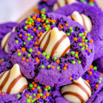 witch hat cookies made in the style of peanut butter blossoms with colorful sprinkles and purple sanding sugar.