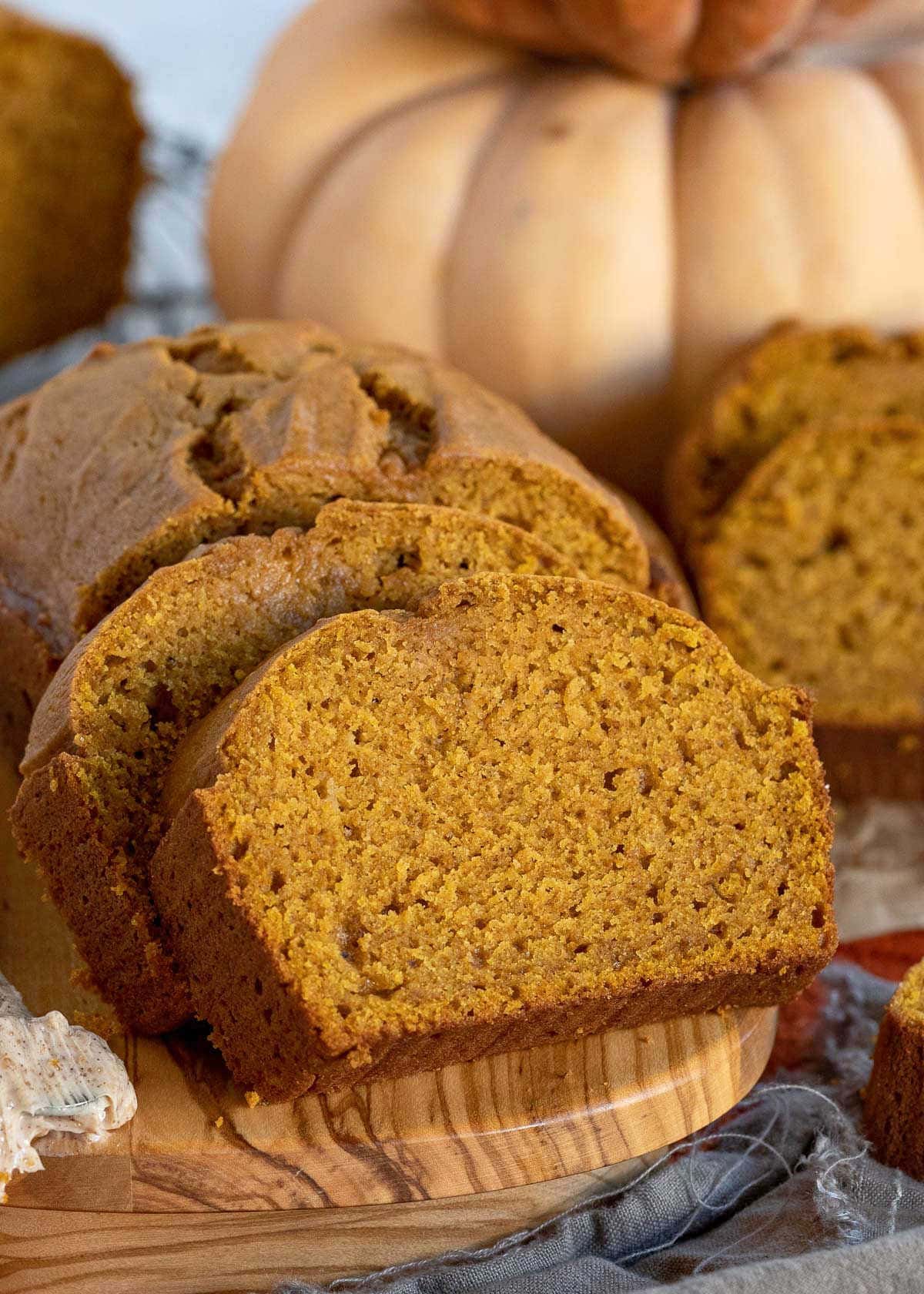 two slices of pumpkin bread leaning up against the rest of the loaf.