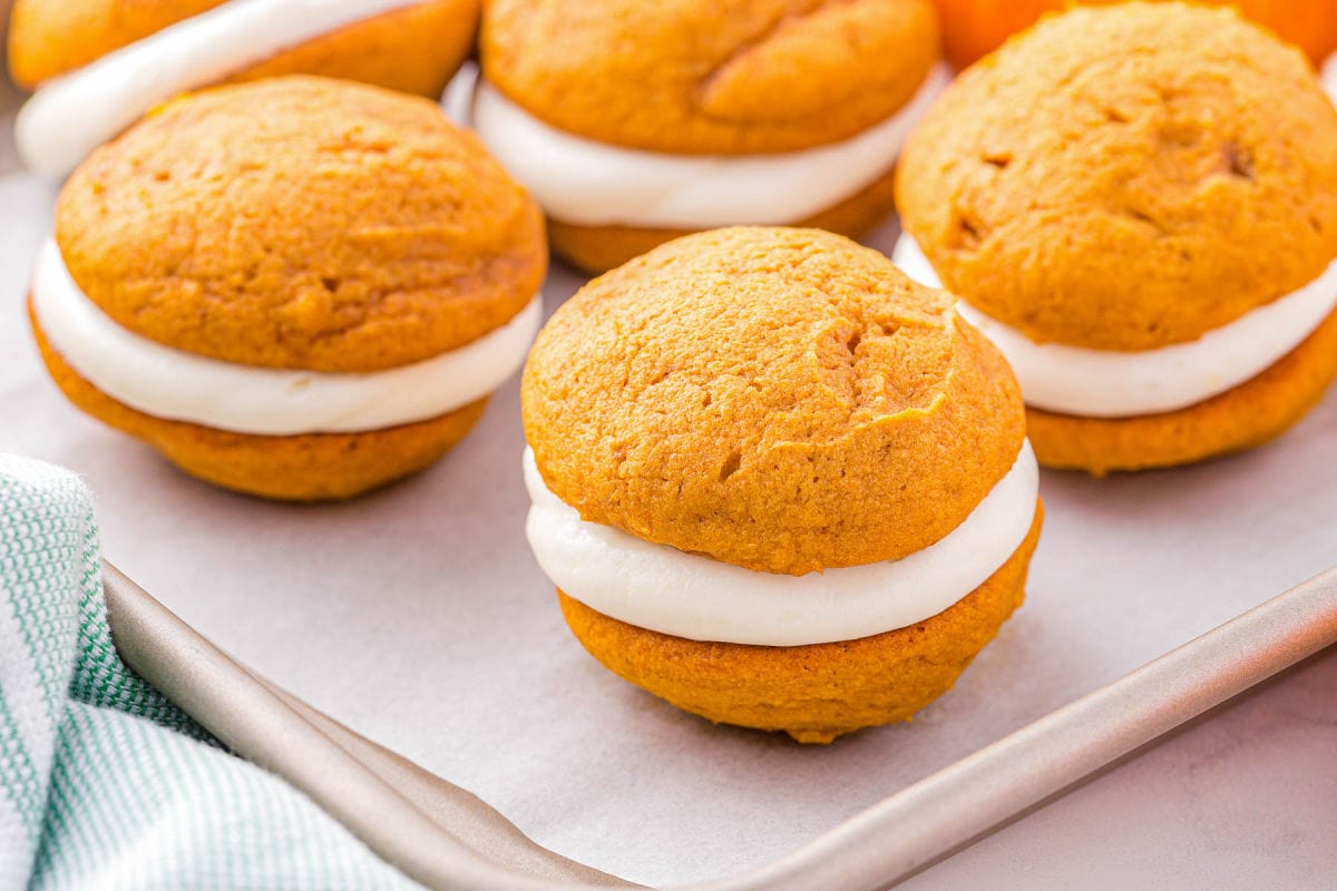 whoopie pies assembled and sitting on a baking sheet on top of a piece of parchment paper.