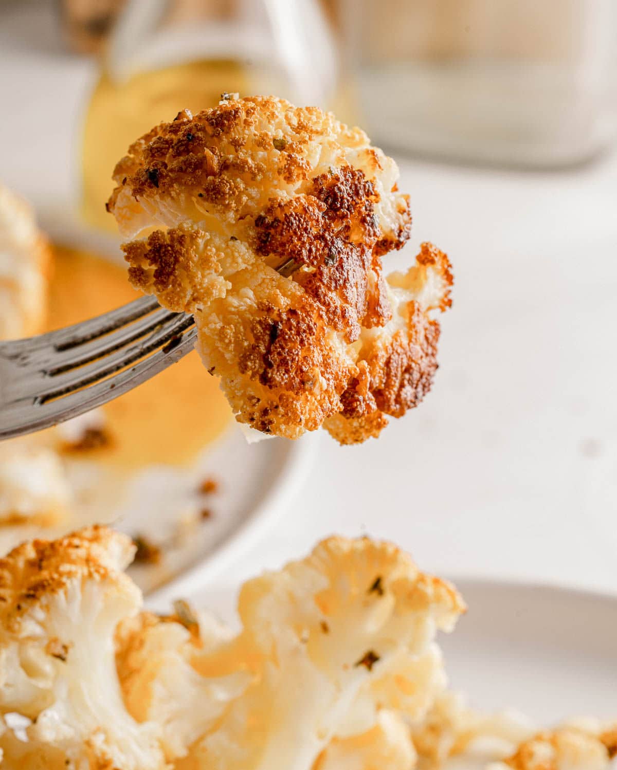 roasted piece of cauliflower held up on a fork.