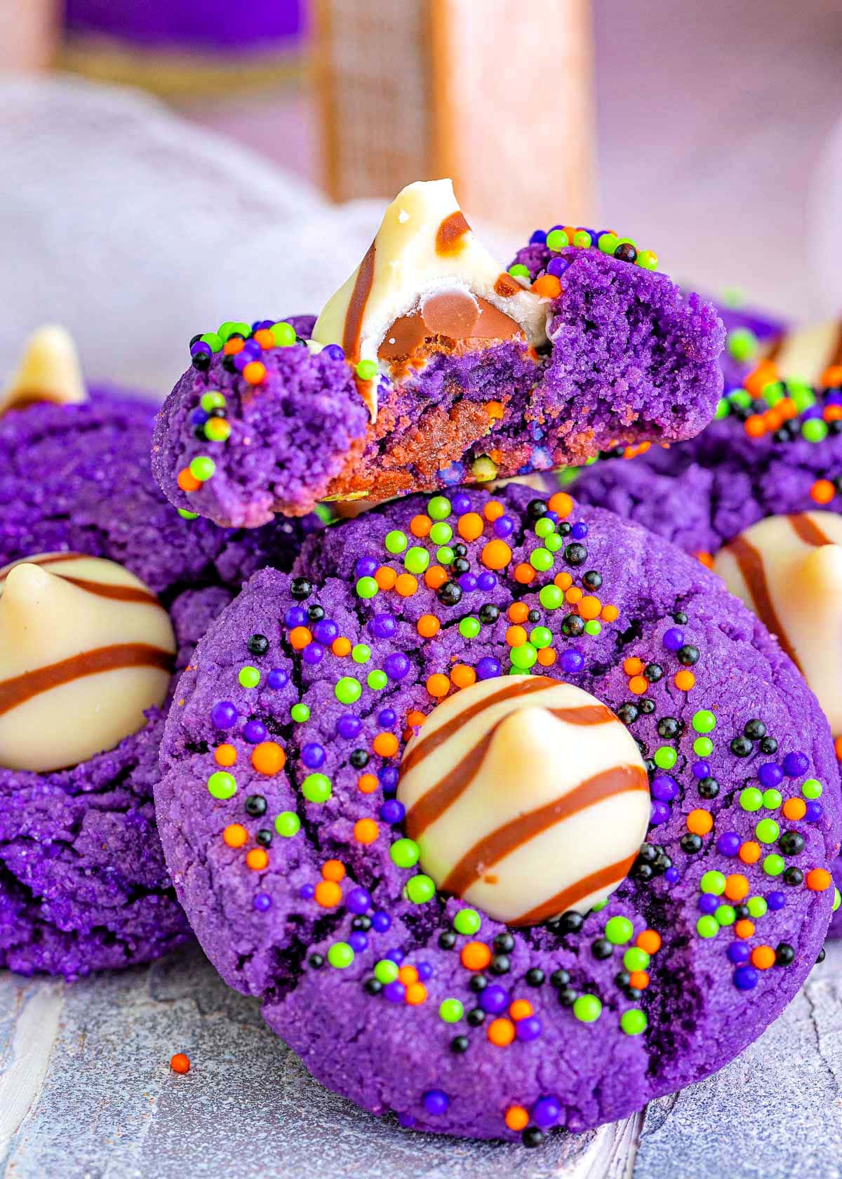 witch hat cookies in a pile with the top cookie bitten in half.