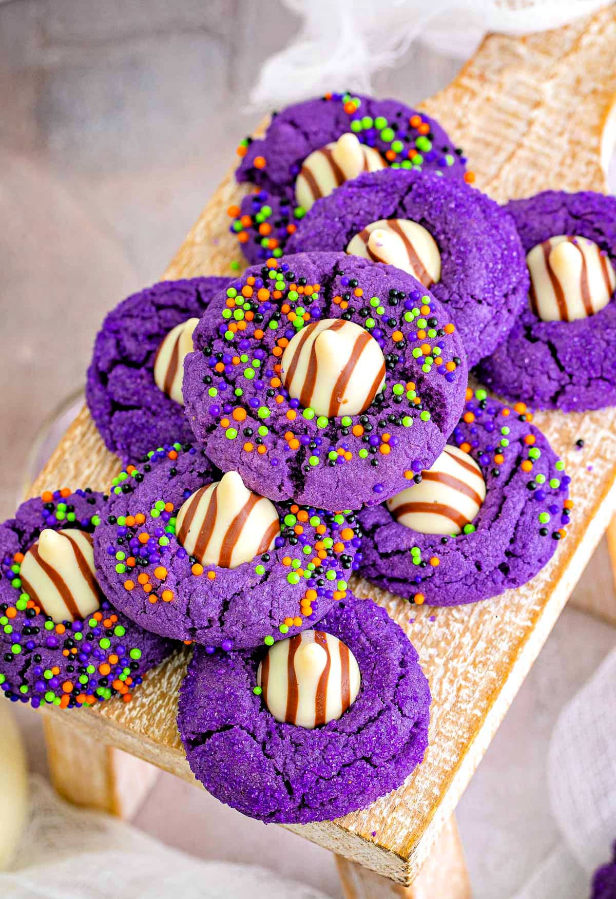 top down look at a stack of purple halloween cookies that look like witch hats sitting on a wood riser.