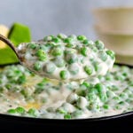 large spoonful of peas ready to be served.