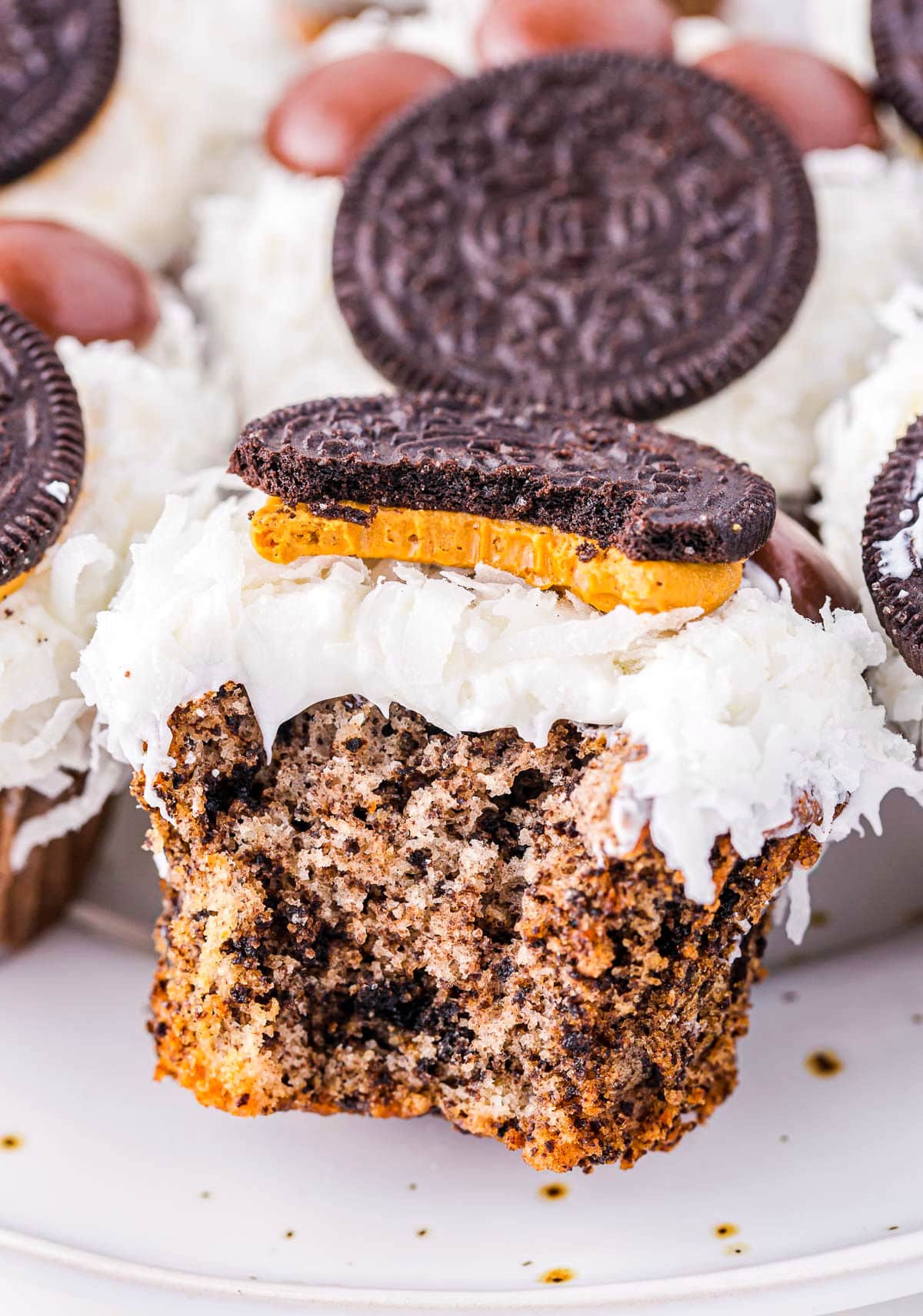 oreo cupcake with bite taken. frosted and deocrated with coconut and oreo cookies and hershey's drops to look like a polar bear paw.