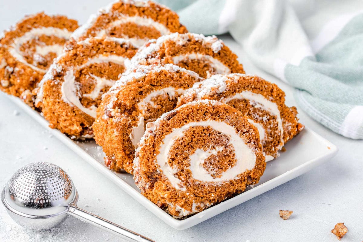 sliced pumpkin roll on a white plate ready to be enjoyed.